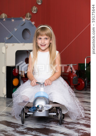 Cute girl is playing with toy cars. Rides a toy 59175644