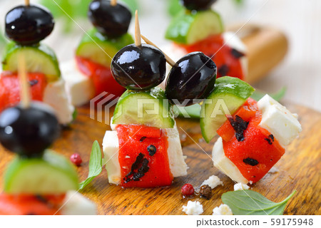 Feta cheese skewers with grilled and pickled red peppers, snack cucumbers and black olives 59175948