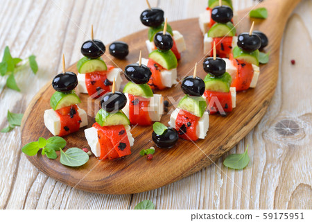 Feta cheese skewers with grilled and pickled red peppers, snack cucumbers and black olives Feta cheese skewers with grilled and pickled red peppers, snack cucumbers and black olives 59175951