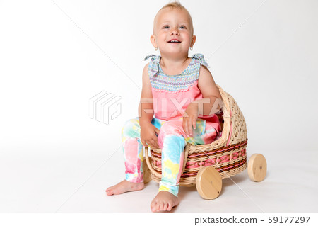 Smiling toddler girl is sitting in the stroller Smiling toddler girl is sitting in the stroller 59177297