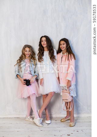 three beautiful fashionable girl girlfriends in pink and white dresses with a camera three beautiful fashionable girl girlfriends in pink and white dresses with a camera 59178533