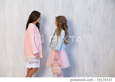 Two beautiful fashionable girl girlfriends in pink and white dresses Two beautiful fashionable girl girlfriends in pink and white dresses 59178535