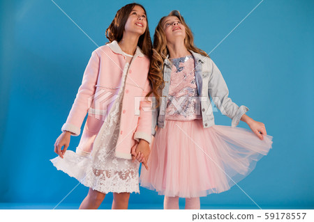 Two beautiful fashionable girl girlfriends in pink and white dresses Two beautiful fashionable girl girlfriends in pink and white dresses 59178557