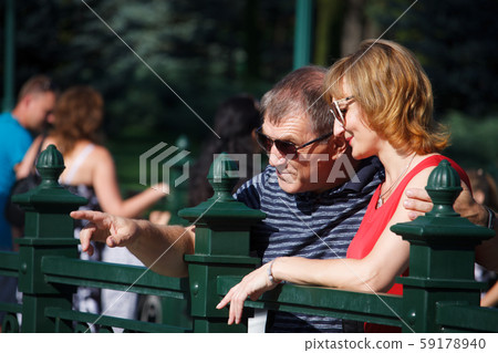 Middle-aged couple smiling and hugging on a walk Middle-aged couple smiling and hugging on a walk 59178940