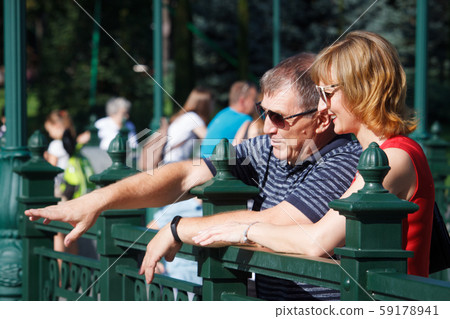 Middle-aged couple smiling and hugging on a walk Middle-aged couple smiling and hugging on a walk 59178941