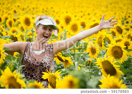 Adult blonde woman in a cap dances, laughs and Adult blonde woman in a cap dances, laughs and 59178983
