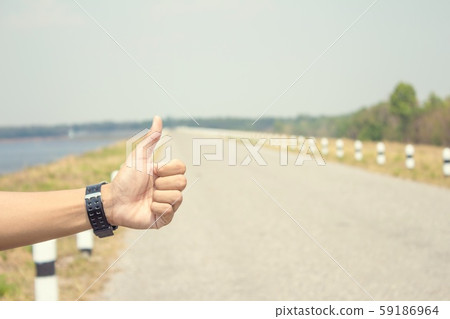 hand hitching car on forest road 59186964