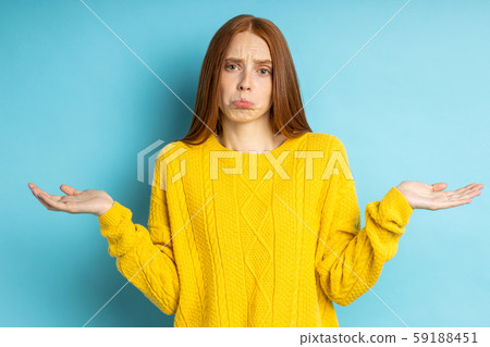 Studio shot of redhead caucasian young woman isolated blue background Studio shot of redhead caucasian young woman isolated blue background 59188451