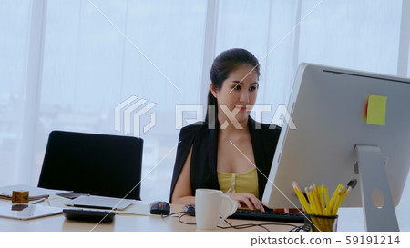 Businesswoman using desktop computer in office. 59191214