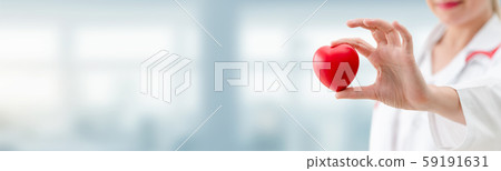 Doctor holding a red heart at hospital office. 59191631