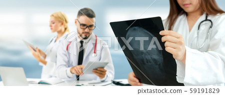 Doctor working in hospital with other doctors. 59191829
