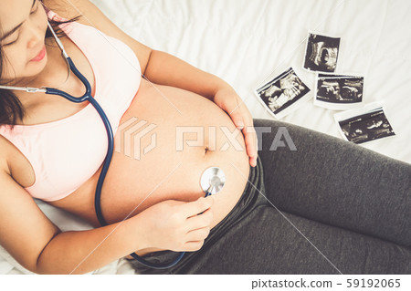 Happy pregnant woman and expecting baby at home. Happy pregnant woman and expecting baby at home. 59192065
