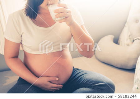 Happy pregnant woman and expecting baby at home. 59192244