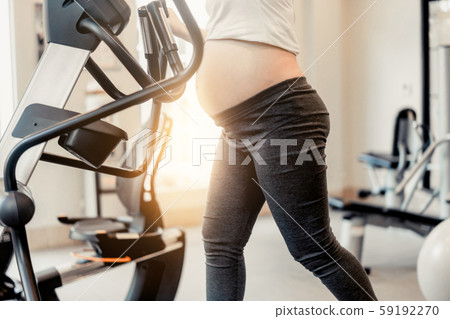 Active pregnant woman exercise in fitness center. 59192270
