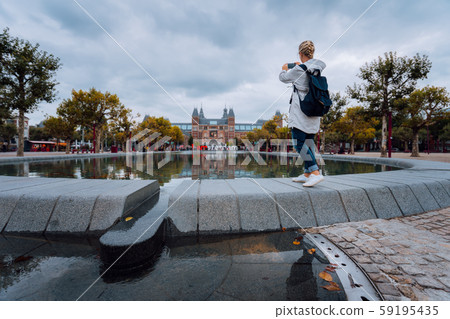 Woman tourist visiting Amsterdam. Travel in Europe city trip concept Woman tourist visiting Amsterdam. Travel in Europe city trip concept 59195435