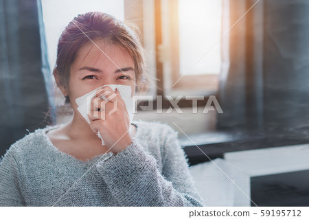 Sick asian woman sneezing on nose with tissue Sick asian woman sneezing on nose with tissue 59195712
