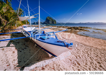 Traditional banca boat at exotic sandy beach with amazing Pinagbuyutan tropical island in background 59196666