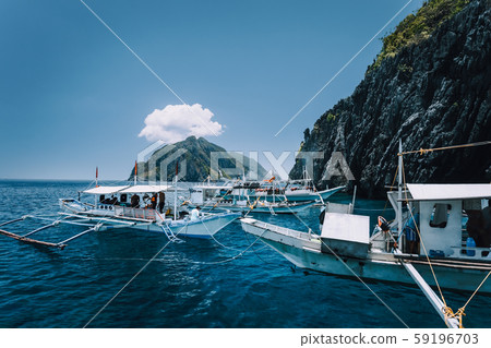 Tourist banca boats on blue sea water surface on island hopping tour. El Nido, Palawan, Philippines 59196703