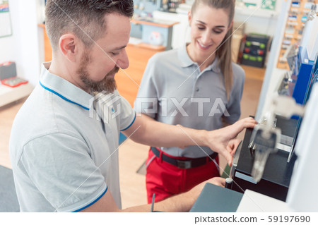 Seller in his shop with customer buying a safe Seller in his shop with customer buying a safe 59197690