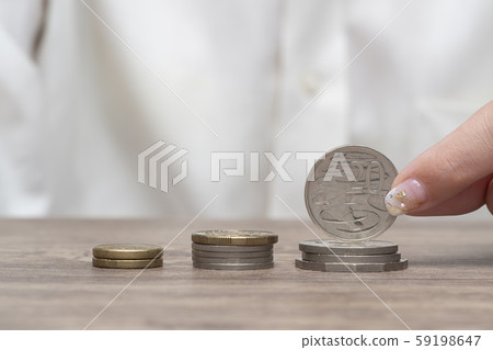 Saving money. Female hand stack coins on table 59198647