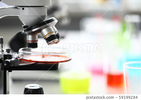 Microscope standing in school chemistry lab among bottles 59199284