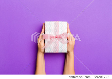 Flat lay of woman hands holding gift wrapped and 59201728