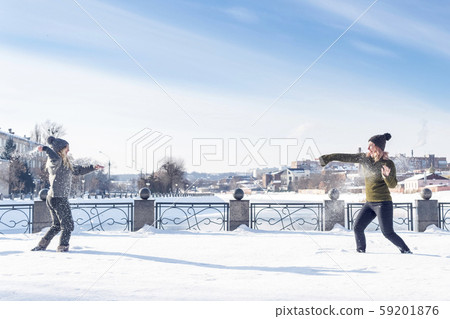 two women play snowballs two women play snowballs 59201876