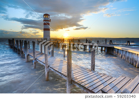 Lighthouse at the end of sea pier. Cold windy Lighthouse at the end of sea pier. Cold windy 59203340