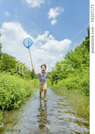 A boy playing in a midsummer creek A boy playing in a midsummer creek 59207173