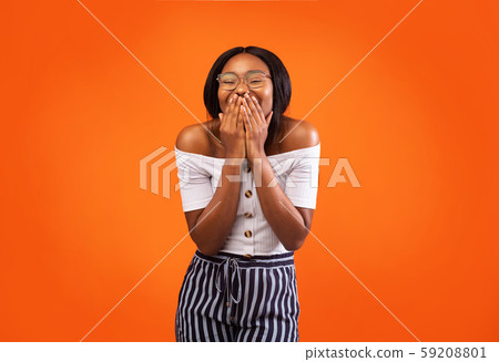 African American Woman Laughing Covering Mouth Standing Over Orange Background 59208801