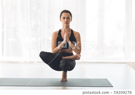 Woman practising yoga at home, sitting on tiptoe Woman practising yoga at home, sitting on tiptoe 59209276