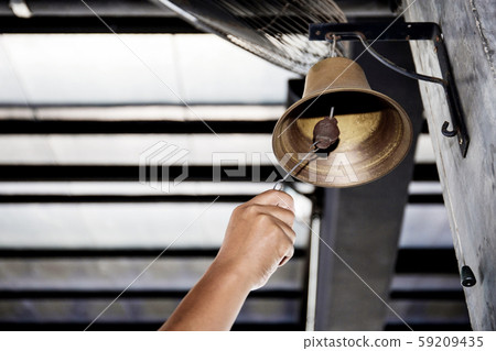 Hand is shaking bell. Hand is shaking bell. 59209435