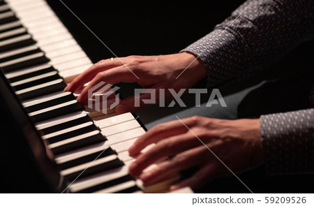 Hands playing piano in a dark theatre blouse white Hands playing piano in a dark theatre blouse white 59209526