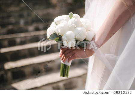 Close up of brides hands with wedding bouquet Close up of brides hands with wedding bouquet 59210153