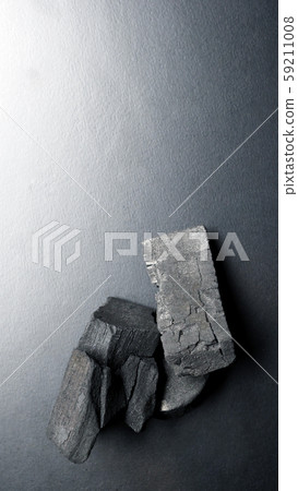 Close-up images of black color charcoal on black background that made from natural wood which represent energy power concept or healthy or use for absorb odor in the room or refrigerator. Close-up images of black color charcoal on black background that made from natural wood which represent energy power concept or healthy or use for absorb odor in the room or refrigerator. 59211008