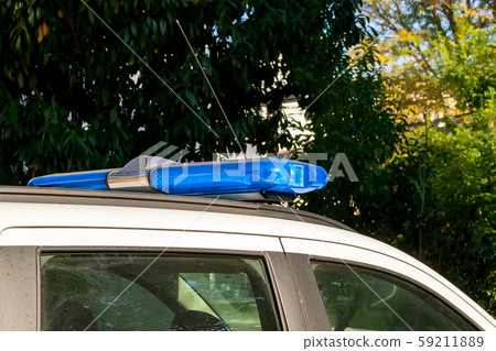 Blue warning lightbar on a police or emergency car. Roof mounted lightbar on a white vehicle. Blue warning lightbar on a police or emergency car. Roof mounted lightbar on a white vehicle. 59211889