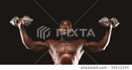 Concentrated black bodybuilder working out, pushing barbells up Concentrated black bodybuilder working out, pushing barbells up 59212293