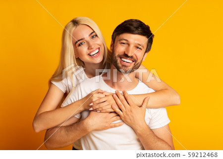 Happy Man And Woman Hugging Standing Over Yellow Background Happy Man And Woman Hugging Standing Over Yellow Background 59212468
