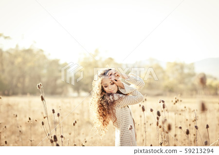 Woman with beautiful long hair posing in field. Woman with beautiful long hair posing in field. 59213294