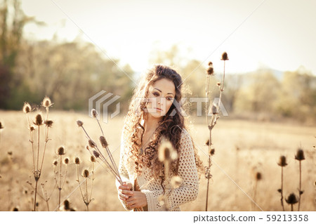 Woman with beautiful long hair posing in field. Woman with beautiful long hair posing in field. 59213358