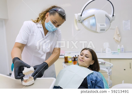 Adult female dentist treating patient woman teeth. Medicine, dentistry and healthcare concept 59213491