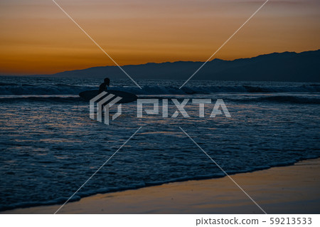 Sunset on the Pacific Coast in California, surfer and joggers run a sport 59213533