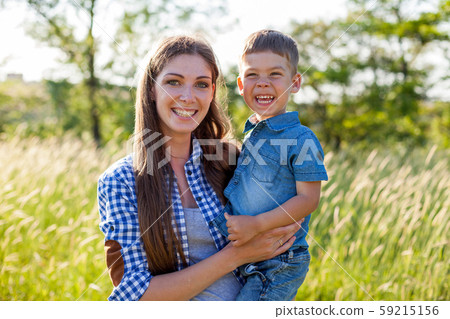 Portrait of a beautiful woman with her son on a walk in nature 59215156