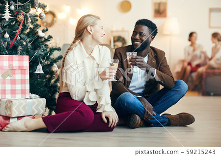 Couple Sitting by Christmas Tree 59215243