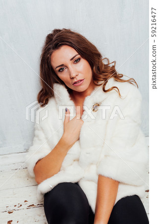 portrait of a beautiful fashionable woman with curls in a white fur coat portrait of a beautiful fashionable woman with curls in a white fur coat 59216477
