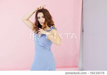 Portrait of a beautiful fashionable woman with curls in a blue dress 59216578