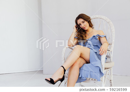 Portrait of a beautiful fashionable woman with curls in a blue dress 59216599