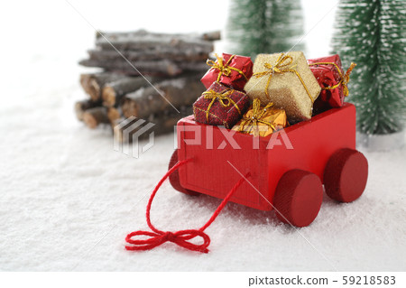Santa Claus carries a present in a red car 59218583