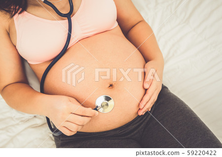 Happy pregnant woman and expecting baby at home. 59220422