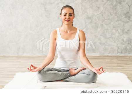 Young woman yoga on carpet at home living room. 59220546